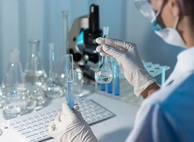 Laboratory technician in gloves holding a flask and a test tube